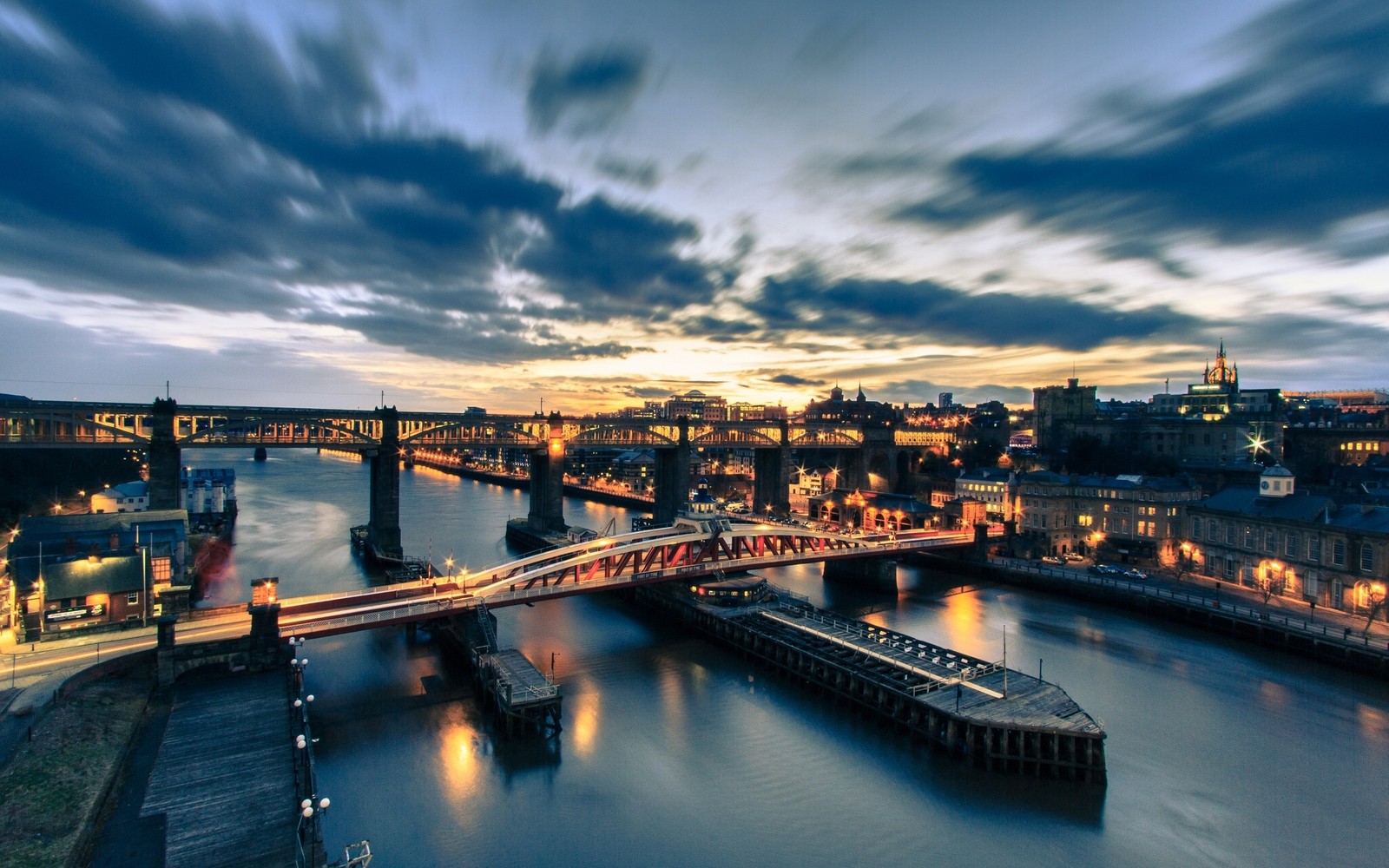 Uma vista de uma ponte sobre um rio com uma cidade ao fundo (gateshead millennium bridge, via navegável, reflexo, flúmen, paisagem urbana)