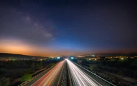 Noche estrellada sobre Limassol: trazas de luz en la carretera bajo la Vía Láctea