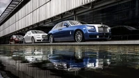 Sleek Rolls Royce lineup reflecting elegance and luxury by the water.