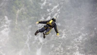 Base Jumper im freien Fall über unwegsames Gelände