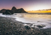 Coucher de soleil serein sur une côte rocheuse