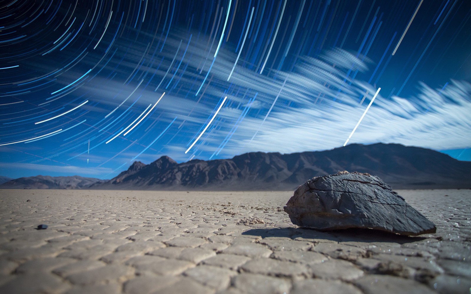 A close up of a rock in the middle of a desert (landscape, nature, cloud, atmosphere, night)