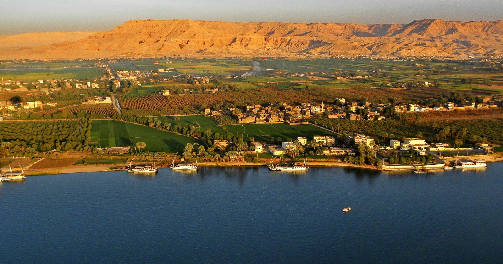 Arafed view of a city and a body of water with a mountain in the background (reflection, water, water resources, reservoir, lake)