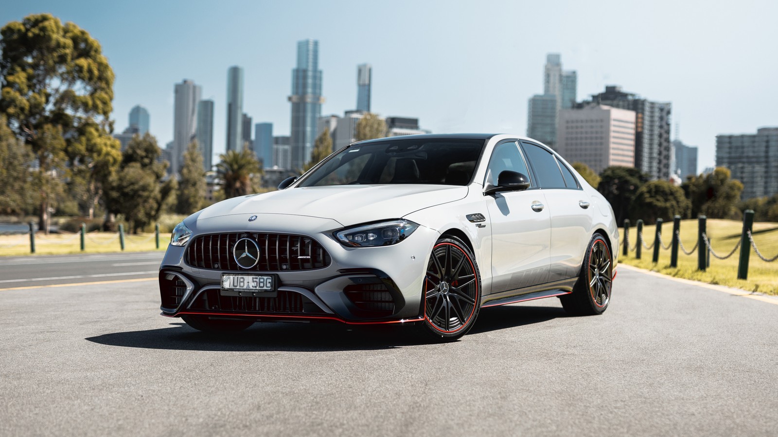 The mercedes amg gts is parked on a road in front of a city skyline (mercedes amg c 63 s e performance f1 edition, 2024, 5k, cars, 4k wallpaper)