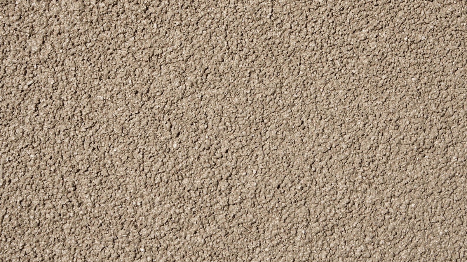 A close up of a wall with a brown stucco texture (soil, sand, gravel, material, grass)