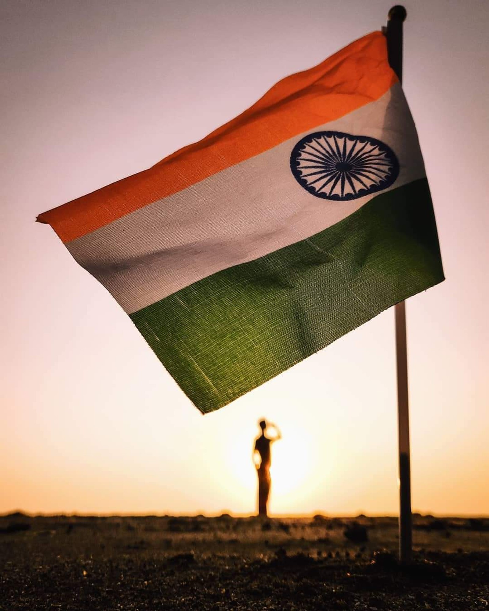 Alguém em pé no deserto segurando uma bandeira com um homem ao fundo (saudação, índia, india, bandeira indiana, myindia)