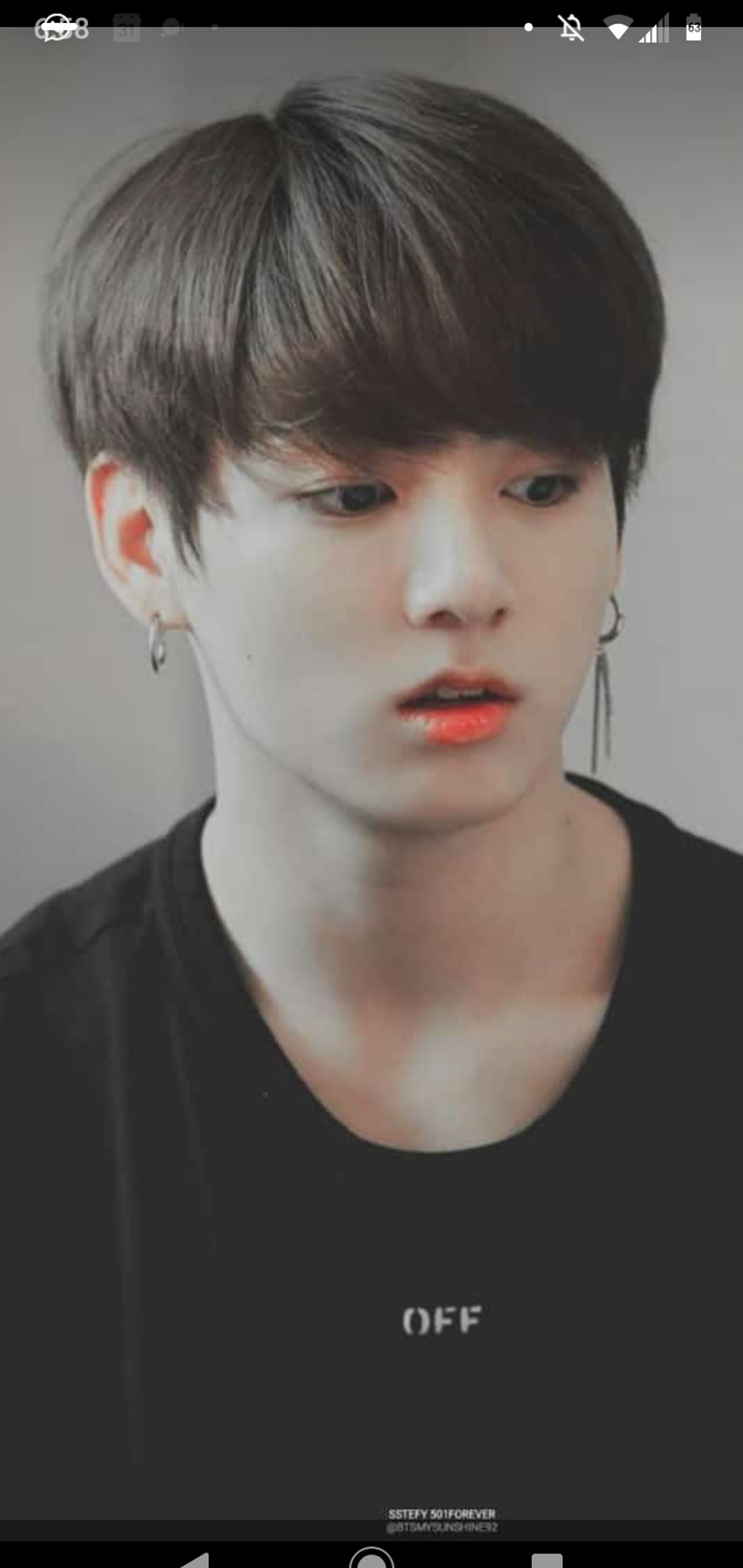 Un gros plan d'une personne portant une chemise noire et des boucles d'oreilles (bangtan, bts, doré, jungkook, kookie)