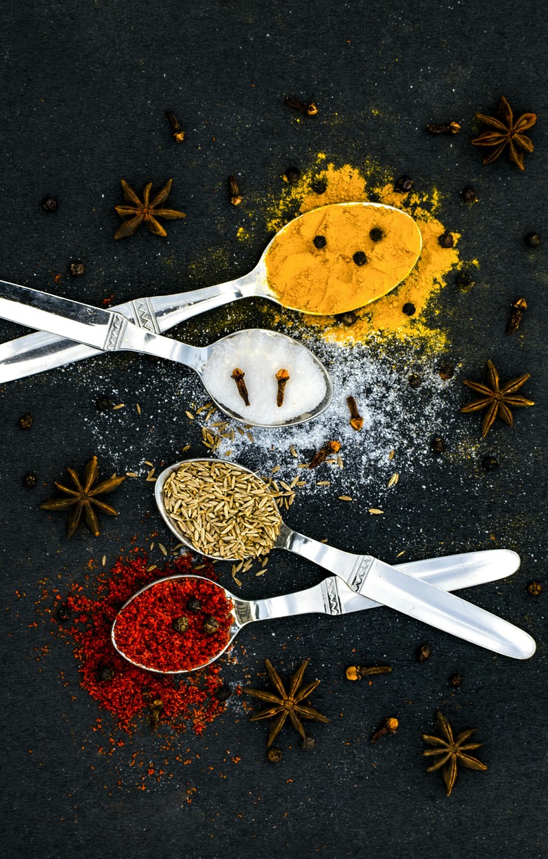 There are spoons and spoons with spices on a table (dark, food, foodphotography, photography, spicey)