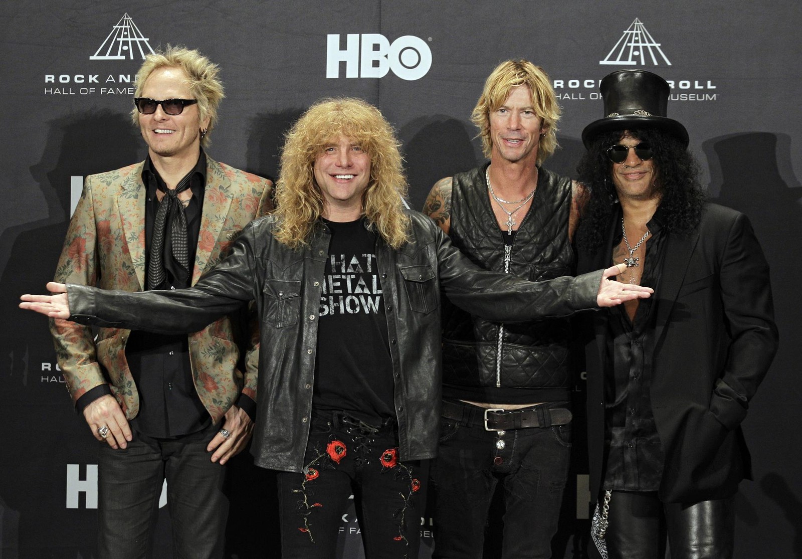 Una imagen posada de miembros de una banda de rock posando para una foto (steven adler, slash, no en este tour de vida, not in this lifetime tour, duff mckagan)