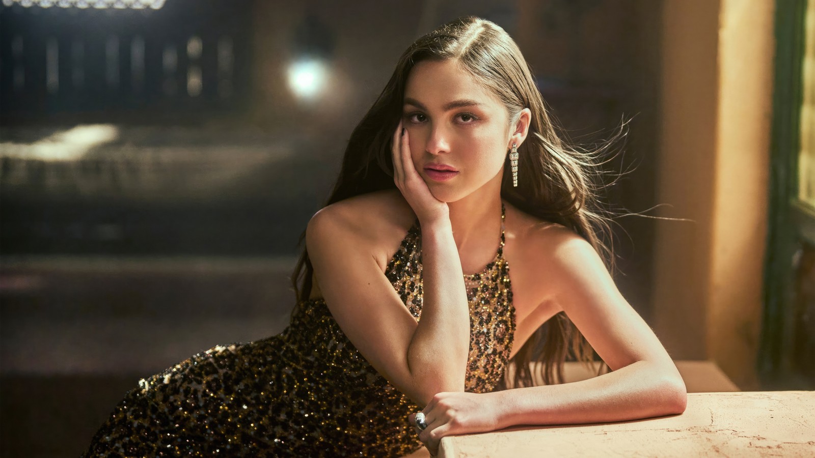 Um close de uma mulher em um vestido de estampa de onça apoiada em uma mesa (olivia rodrigo, 5k, vanity fair, sessão de fotos, pessoas)