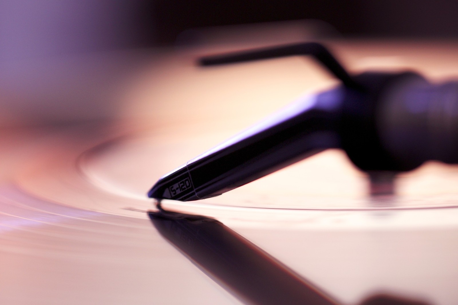 There is a close up of a turntable with a microphone on it (purple, close up, jazz, music)