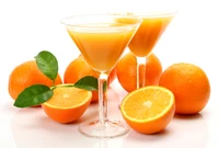 Suco de laranja fresco com laranjas inteiras e folhas