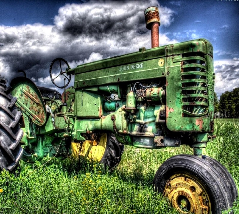 Зеленый трактор, стоящий на траве (old tractor)