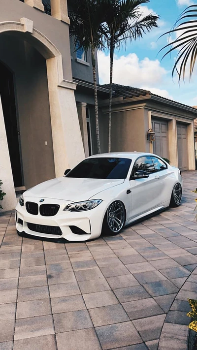 Eleganter weißer BMW M2 Coupé mit Tuning-Details in einer modernen Umgebung