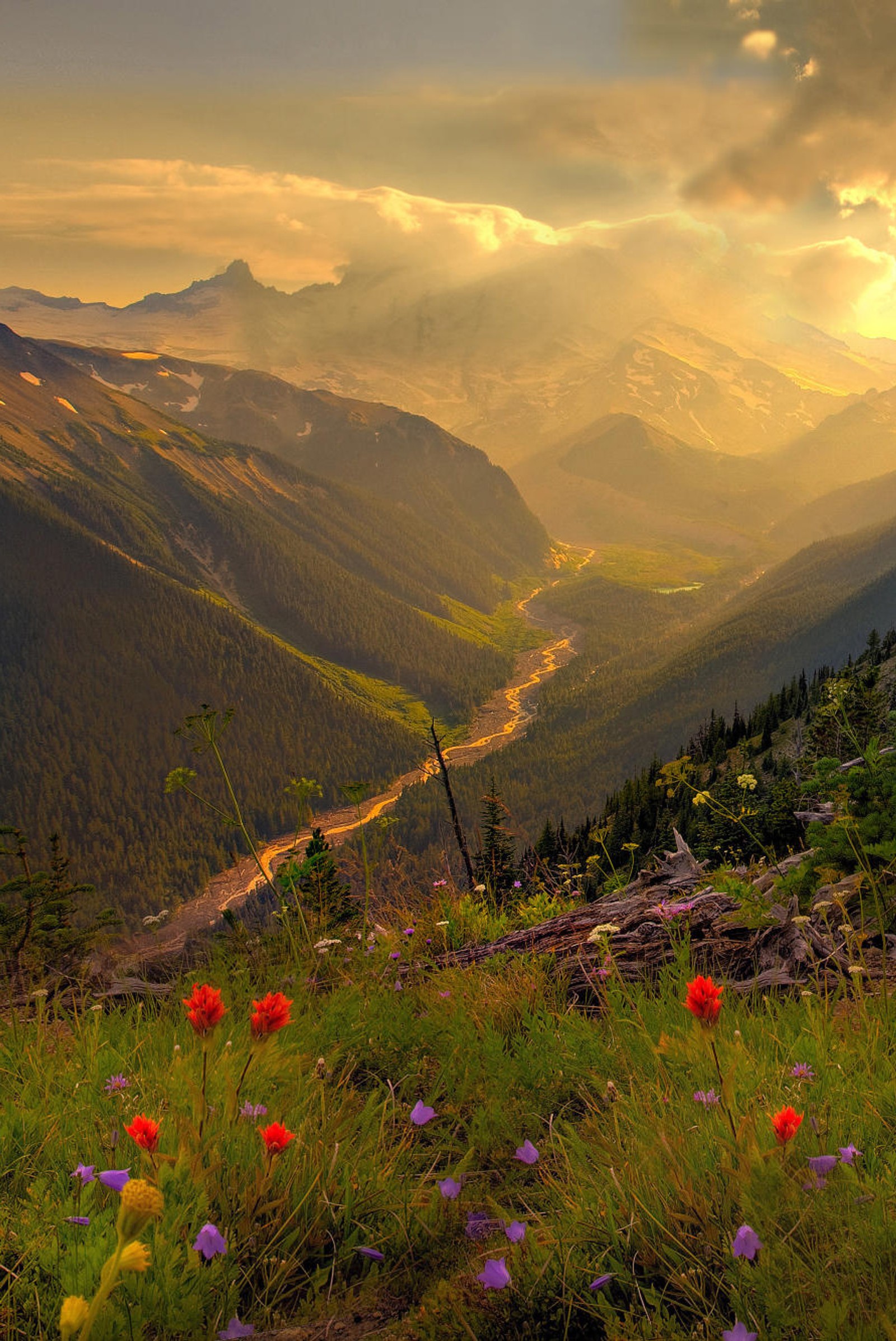 Montanhas com um vale à distância e um rio correndo por elas (paisagem, natureza, cenário)