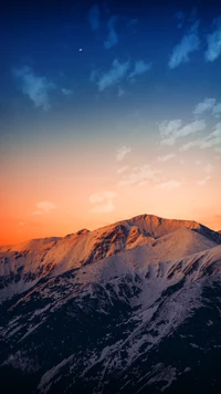 Sereno atardecer en las tierras altas sobre montañas cubiertas de nieve