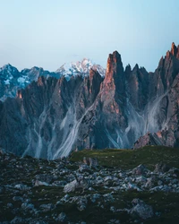 Majestosas Dolomitas ao crepúsculo, exibindo cristas acidentadas e formas de relevo glaciares em meio a uma natureza selvagem serena.