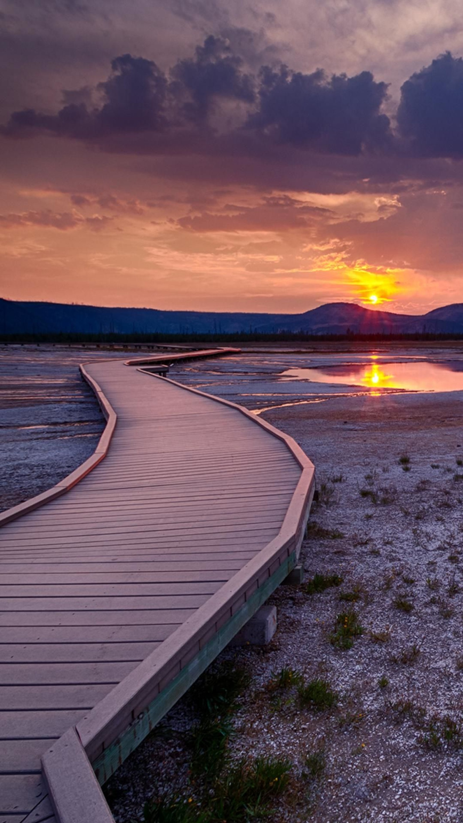 Promenade de skateurs menant à un lac au coucher du soleil avec des montagnes en arrière-plan (coucher de soleil, horizon, paysage naturel, nuage, mer)