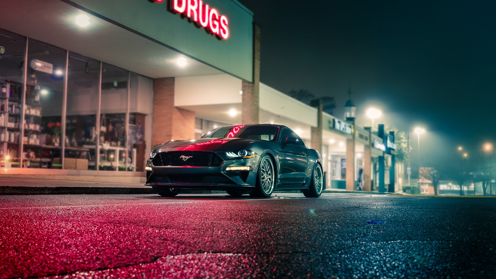 Un primer plano de un coche estacionado frente a un edificio (ford mustang, noche, luces de la ciudad, neón, coches)