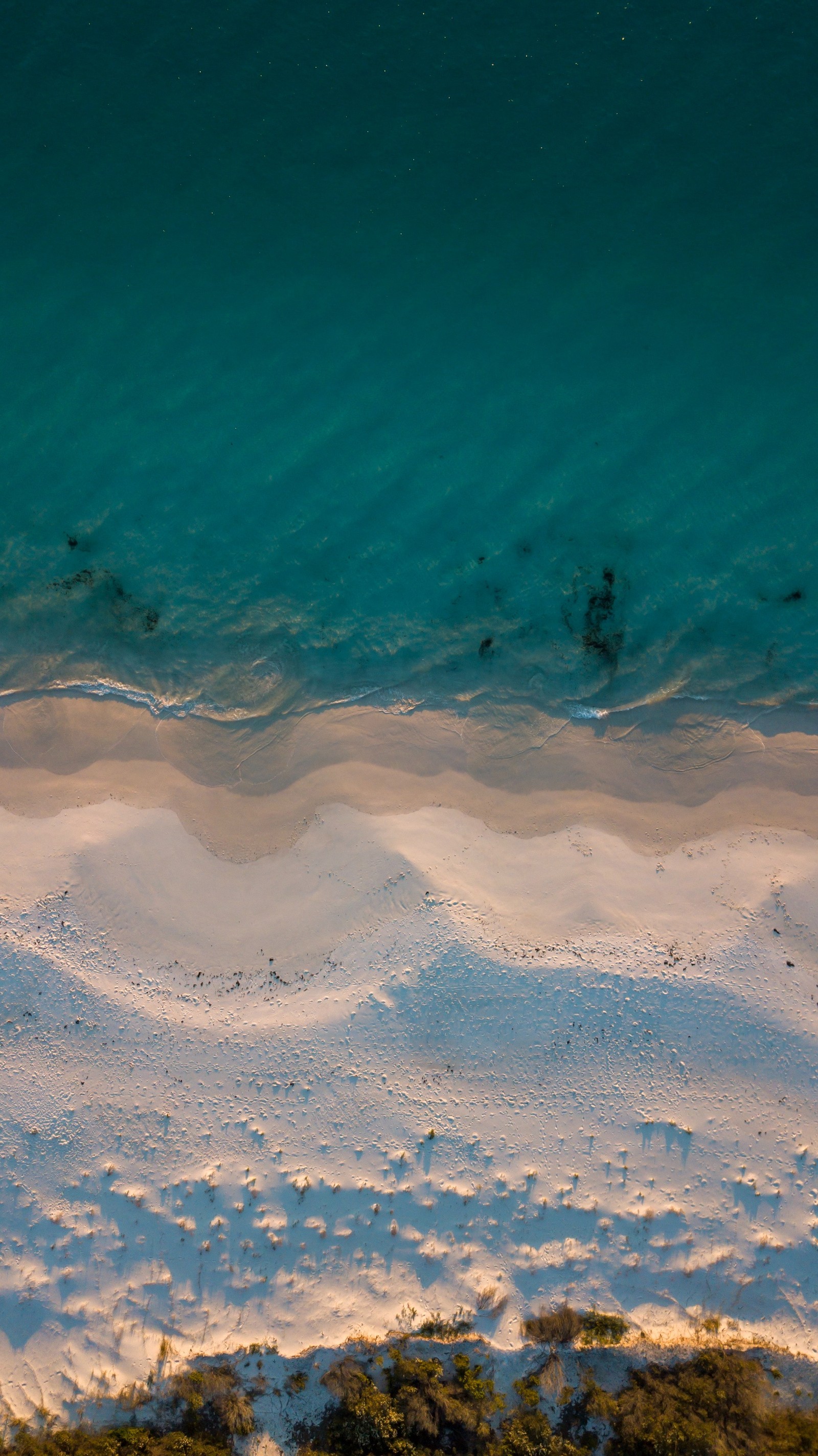 Luftaufnahme eines strandes mit einem einsamen surfbrett im wasser (strand, meer, blau, wolke, turquoise)