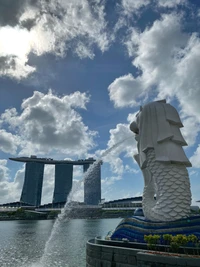 Estátua do Merlion com Marina Bay Sands ao fundo sob um céu nublado, um marco proeminente em Cingapura.