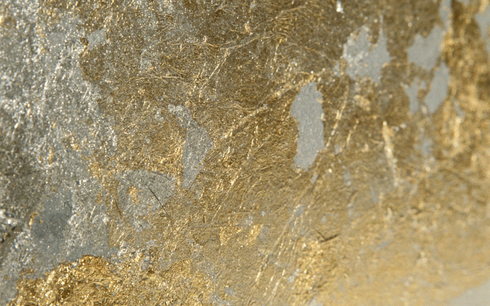 A close up of a gold and silver wall with a clock (rock, geology, mineral)