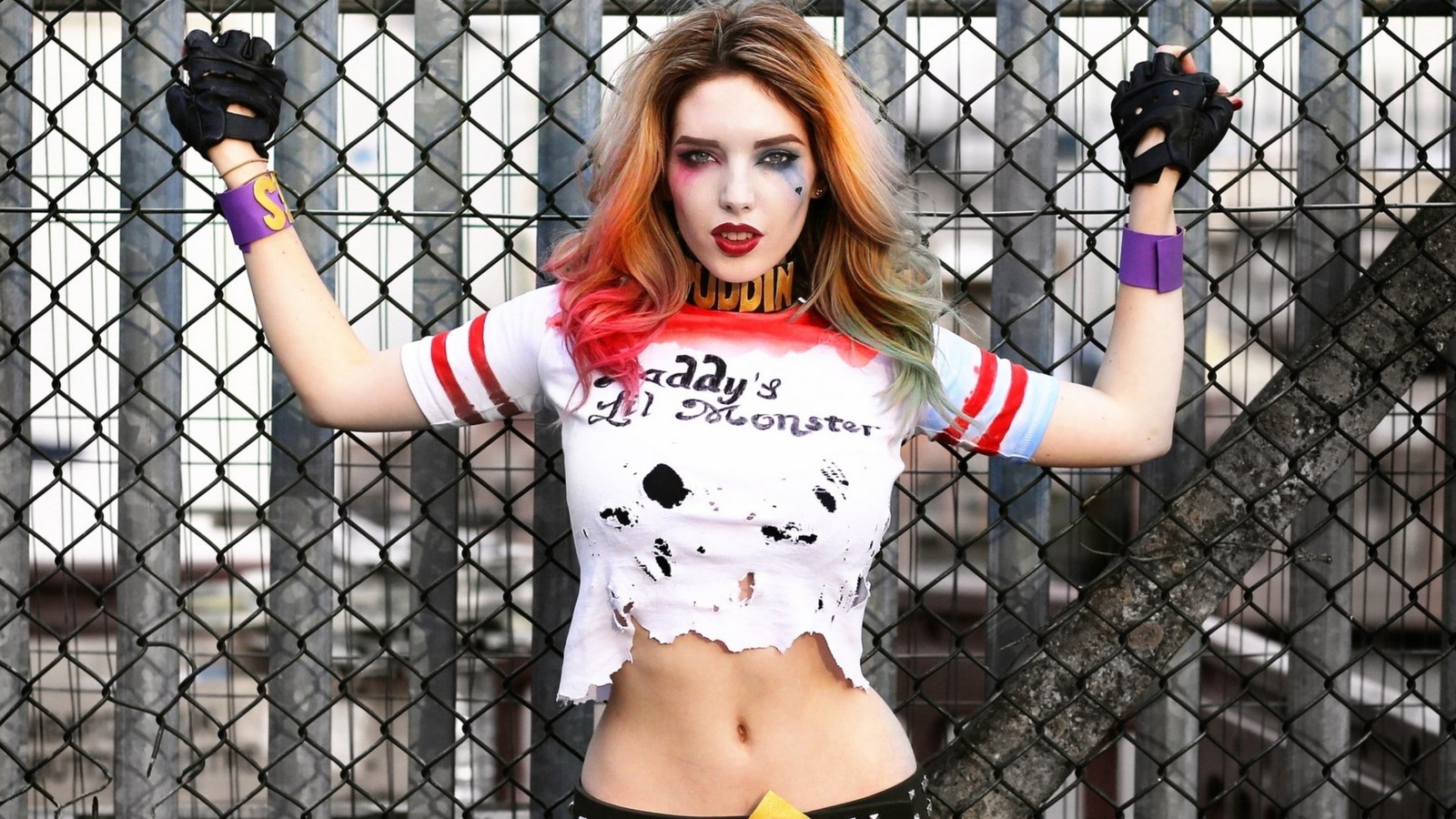 Fille arabe avec des cheveux rouges et du maquillage posant devant une clôture (harley quinn, lèvre, bras, épaule, muscle)