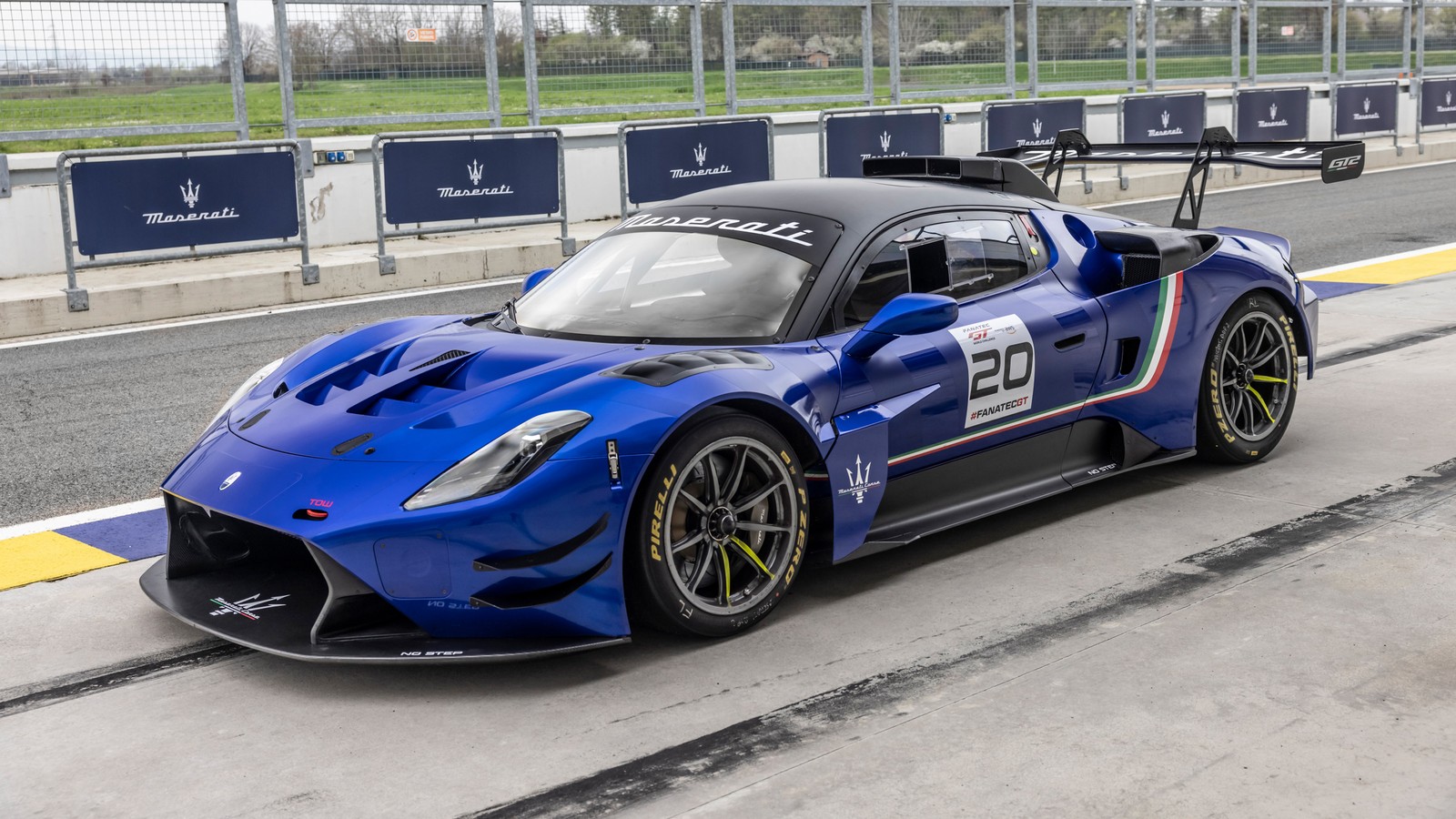 Um carro esportivo azul dirigindo em uma pista ao lado de uma cerca (maserati gt2, pista de corrida, carros de corrida, 2024, 5k)