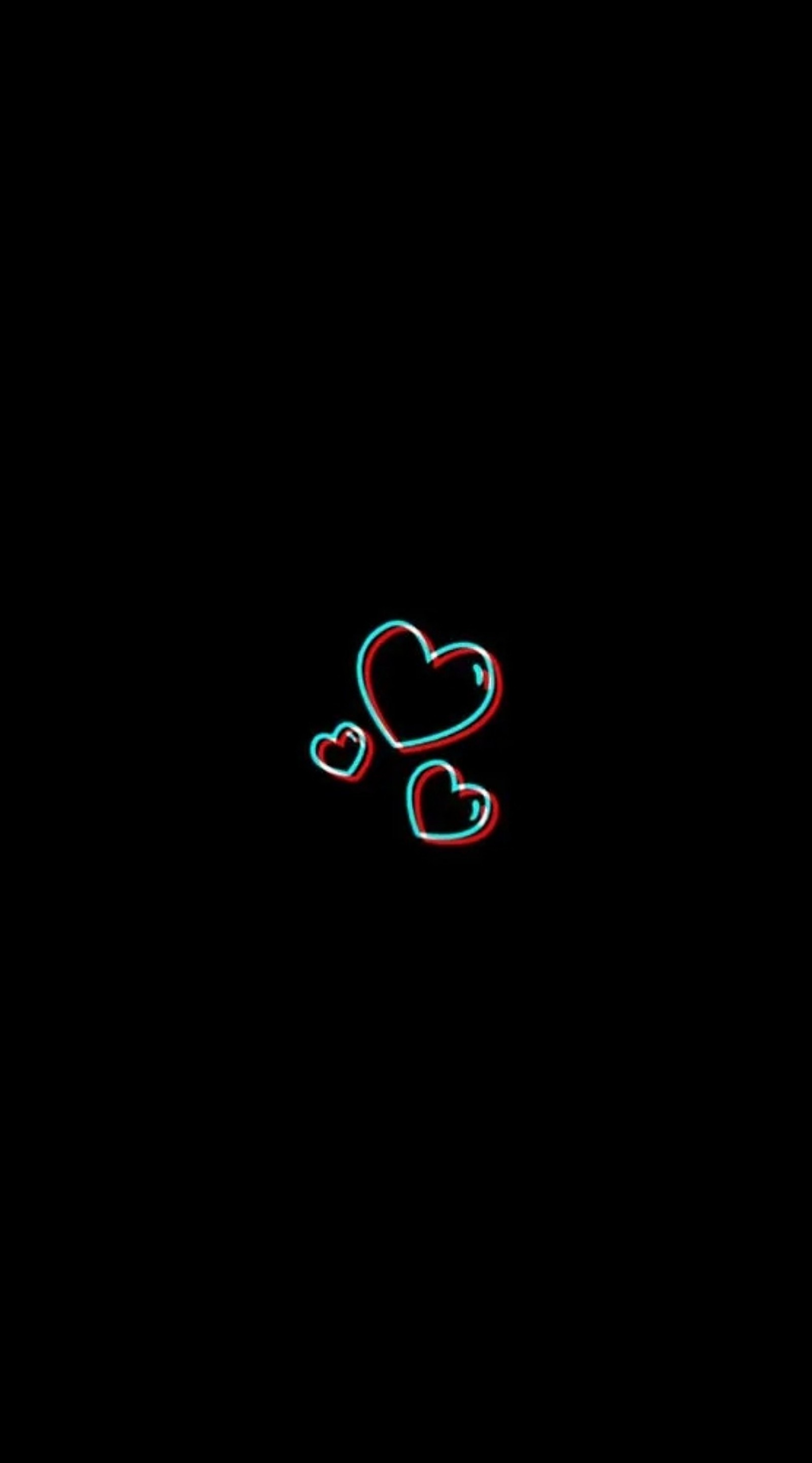 There is a heart shaped object in the dark with a red and blue light (black, hearts, sad)