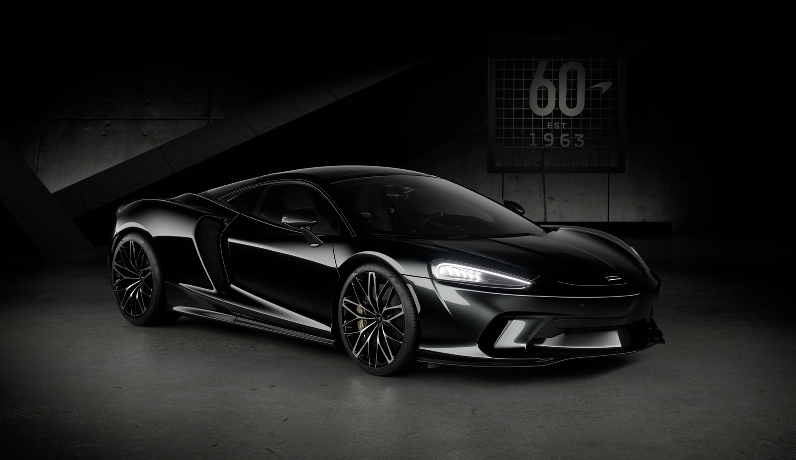 Un primer plano de un coche deportivo negro en una habitación oscura (mclaren gt, edición de aniversario, 5k, fondo oscuro, coches negros)