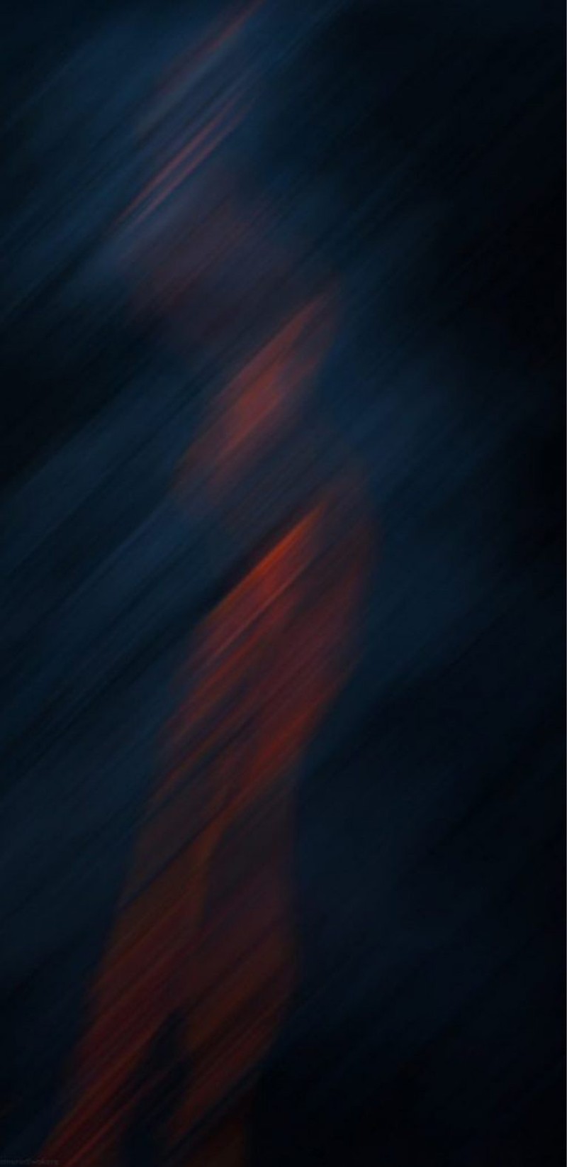 Blurry photograph of a person riding a skateboard on a dark surface (blue, mobile, red, wallpaper)