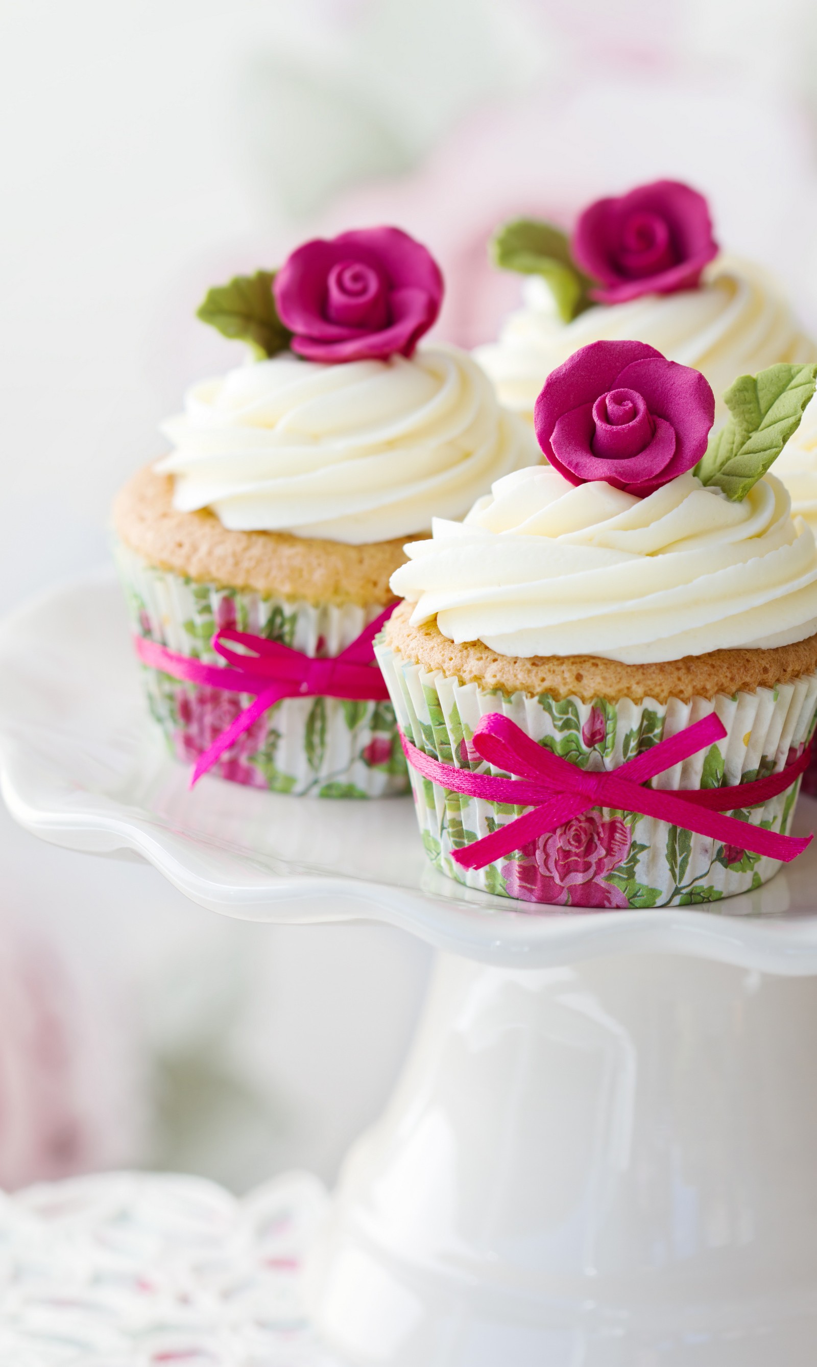 Deux cupcakes avec un glaçage blanc et des fleurs roses dessus (cupcakes, fleurs, roses)