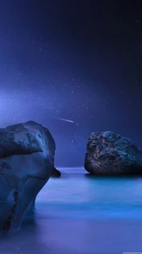 Un paisaje nocturno sereno con un océano azul tranquilo, rocas iluminadas y un cielo estrellado con una estrella fugaz.