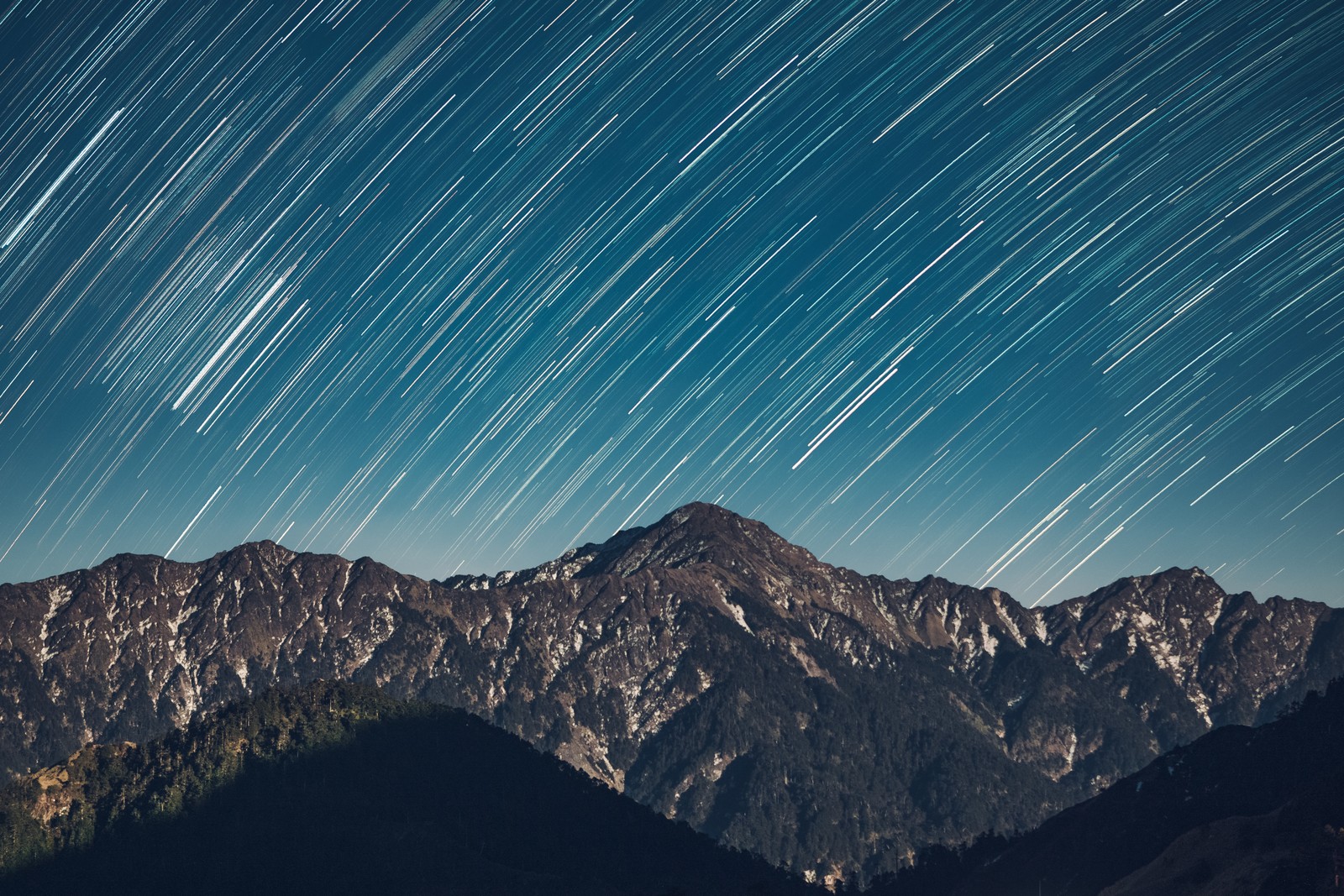 Uma vista de uma montanha com uma trilha de estrelas no céu (rastro de estrelas, cadeia de montanhas, astronomia, padrão, espaço sideral)