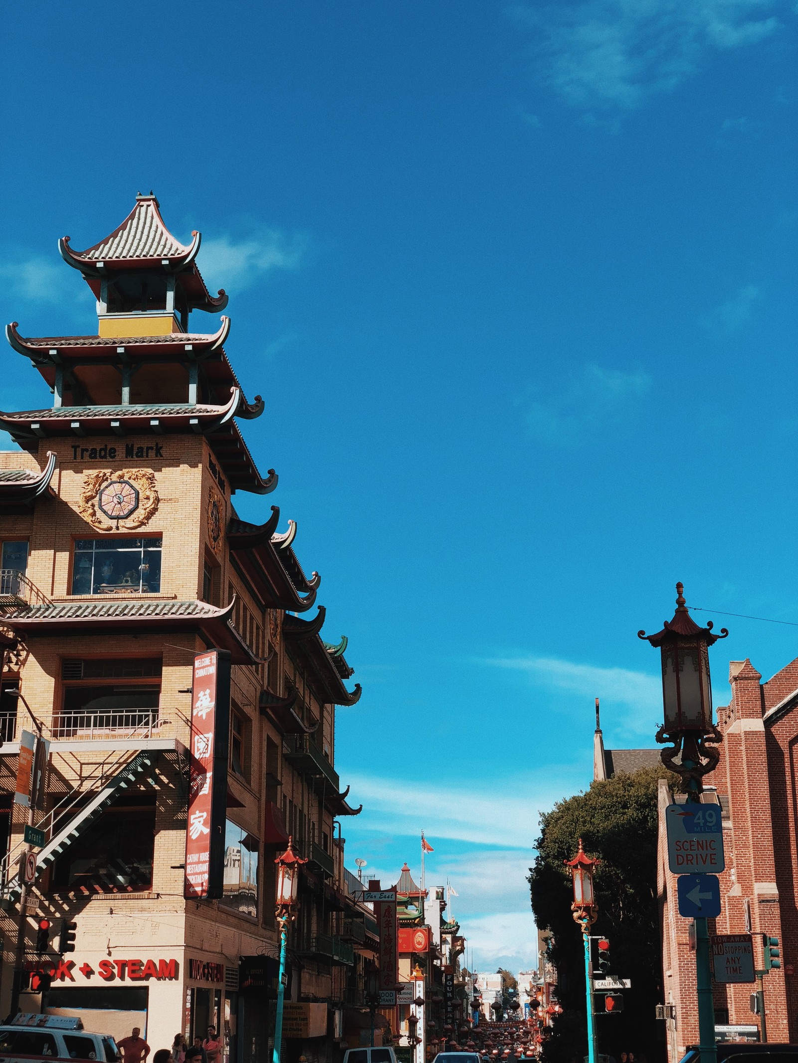 Hay un edificio alto con un reloj en la parte superior. (chinatown, turismo, atracción turística, pueblo, camino)