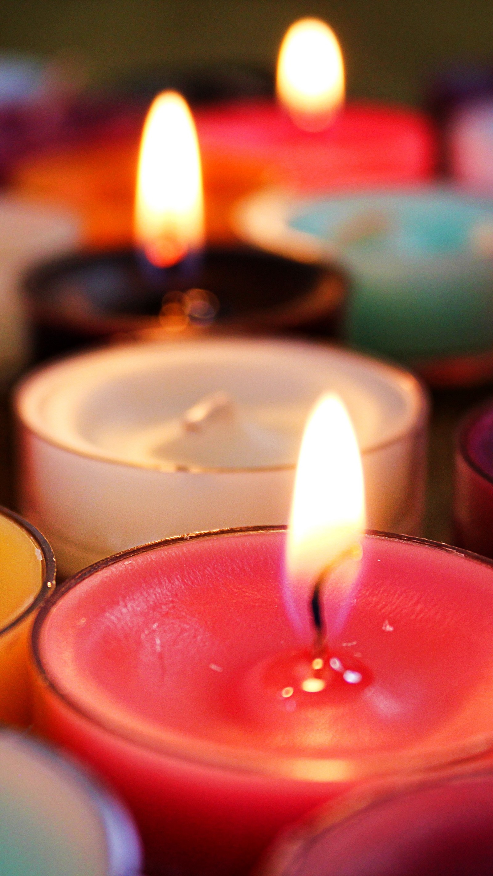 Candles are lit in a row on a table with other candles (candle, candle wick, flame, lighting, light)