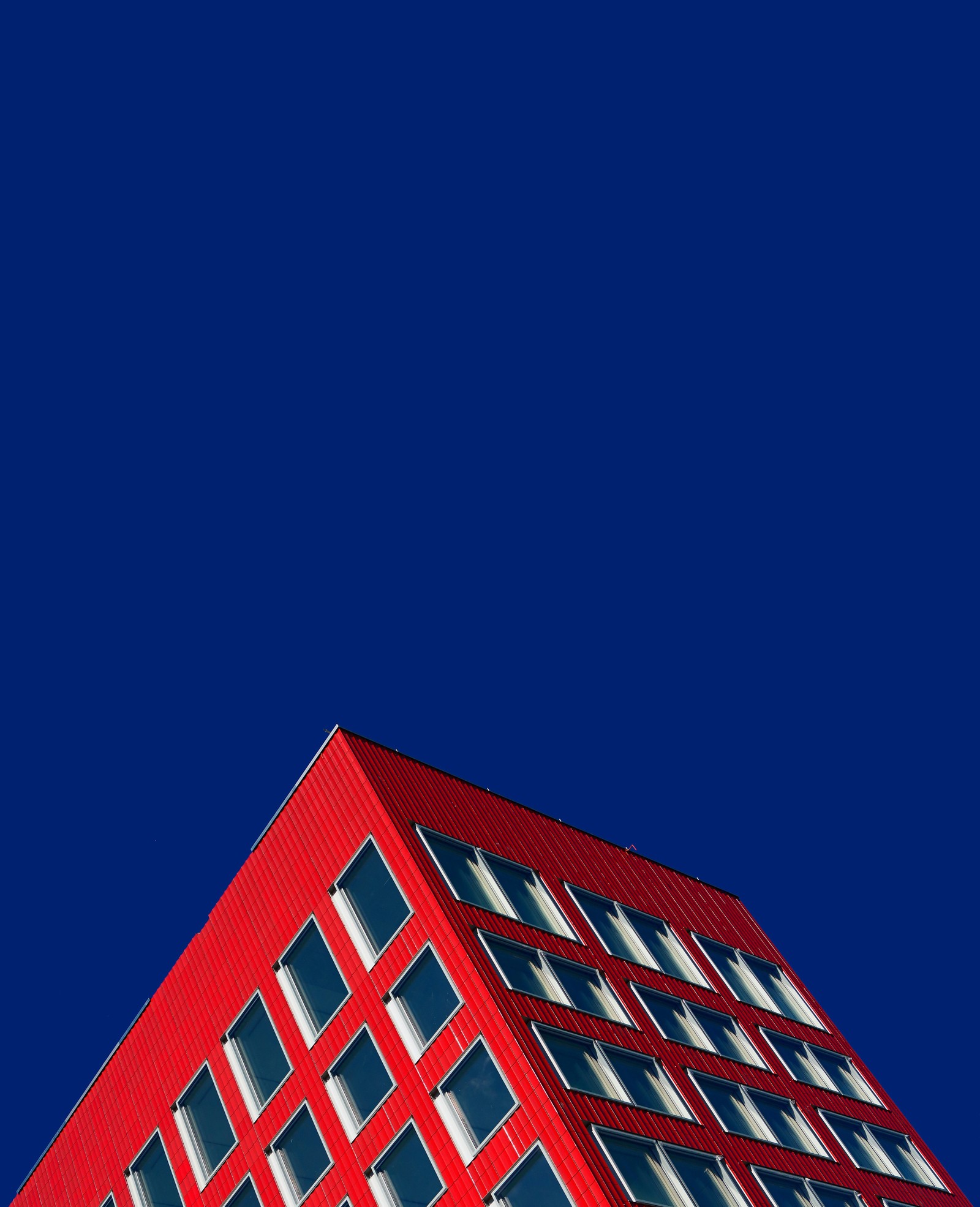 Un bâtiment rouge avec une horloge au sommet (red building, ciel bleu, ciel dégagé, géométrique, photographie en contre plongée)