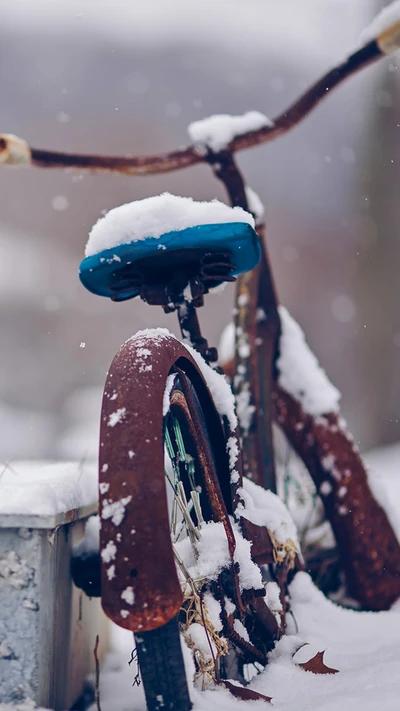 Rusty bicycle partially covered in snow, set against a winter backdrop.