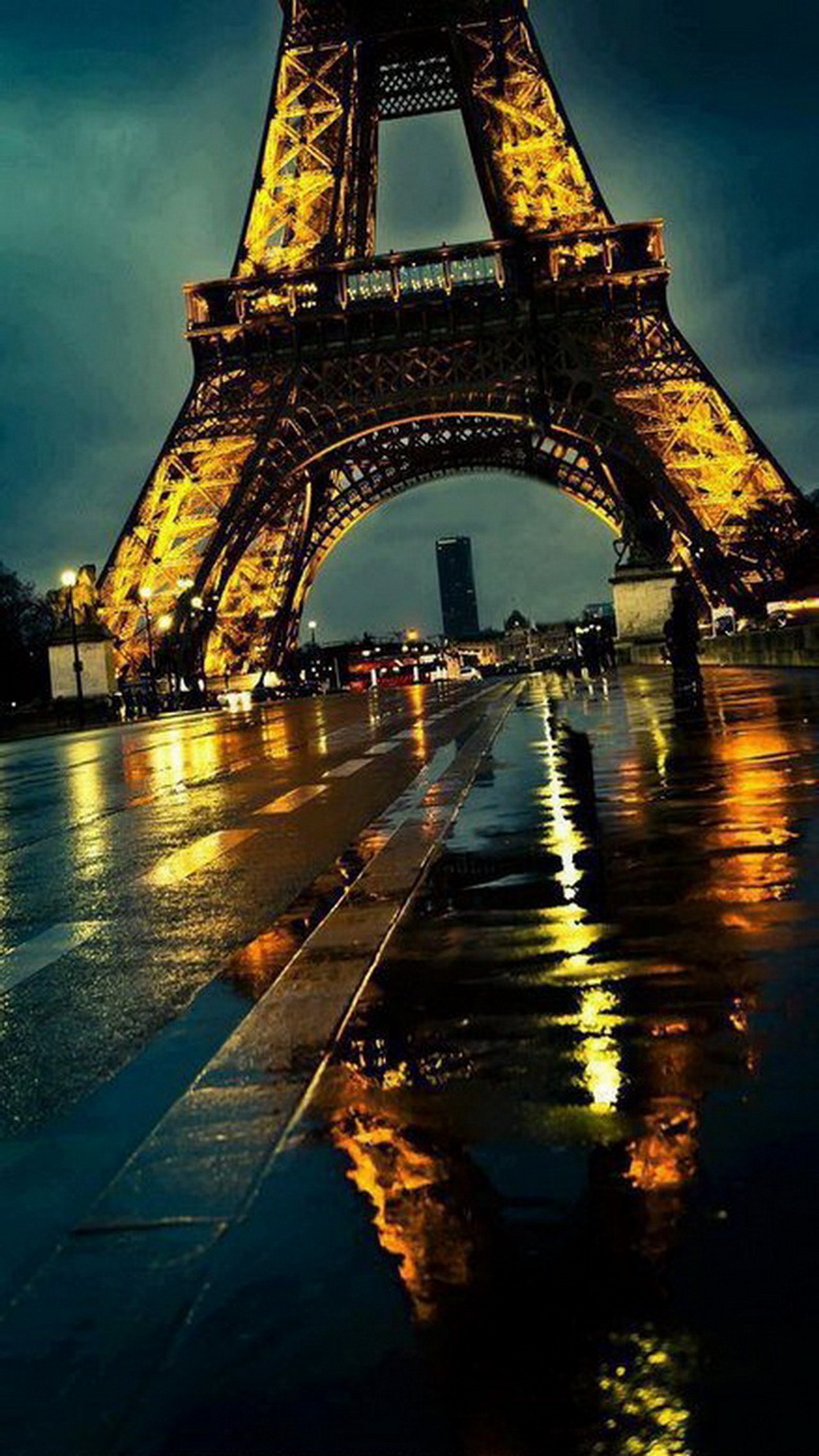 Um close de uma torre muito alta com muitas luzes. (torre eiffel, frança, noite, paris, chuva)