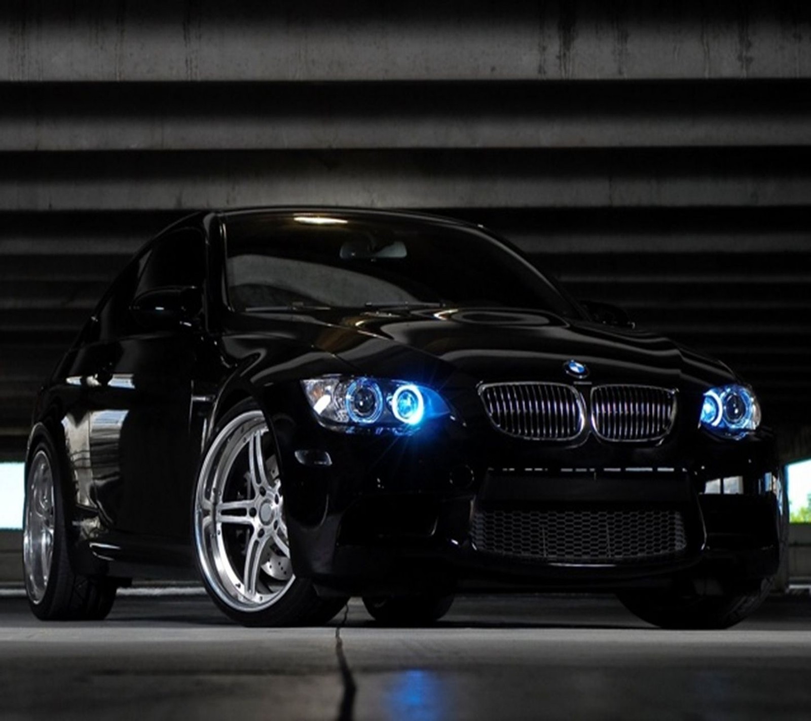 A close up of a black car parked in a parking garage (auto, black, blue, bmw, car)