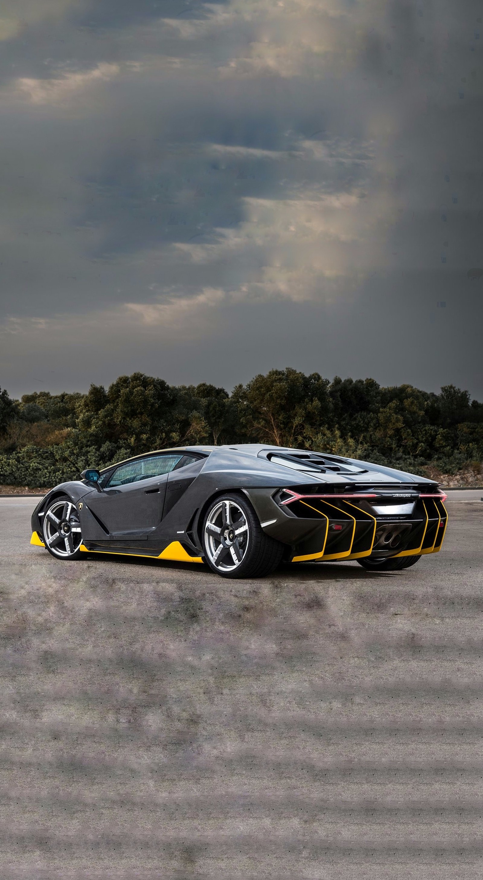 A close up of a black and yellow sports car on a road (car, cars, centenario, fast, hypercar)