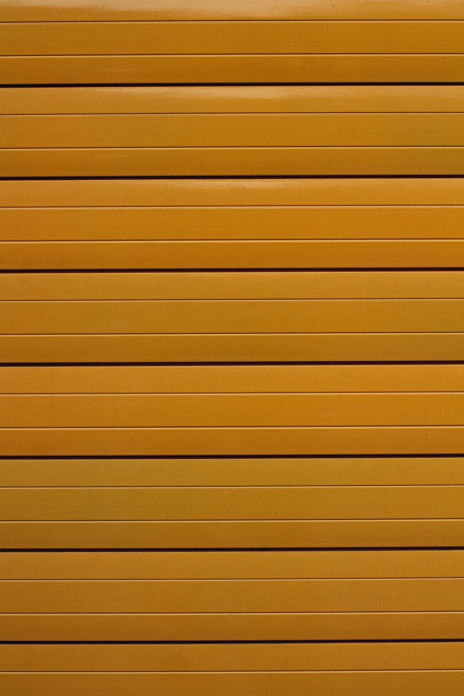 Un mur en métal jaune avec des lignes horizontales et un hydrant rouge (teinture pour bois, parallèles, ligne, bois, jaune)