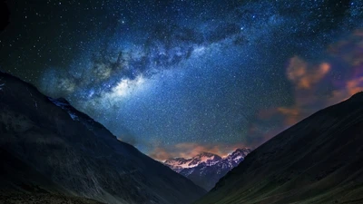 Majestuosa Vía Láctea sobre paisaje montañoso por la noche