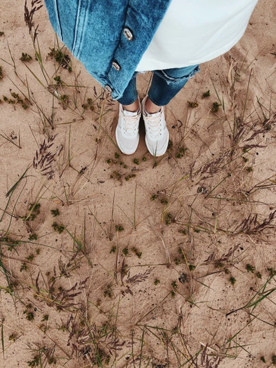 Durch grasigen Sand gehen: Eine Jeansperspektive