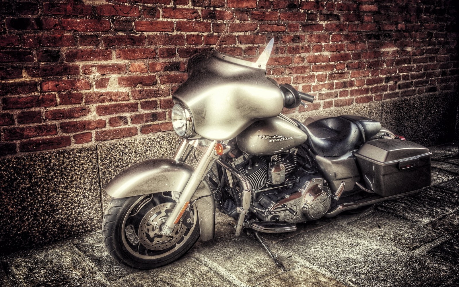 Uma motocicleta estacionada ao lado de uma parede de tijolos (motocicleta, carro, farol, ferro, pneu automotivo)