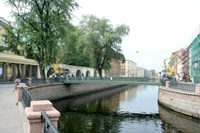 Ruhiger Kanal, flankiert von üppigen Bäumen und historischer Architektur