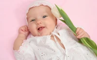 Bebê alegre em rosa com um tulipa