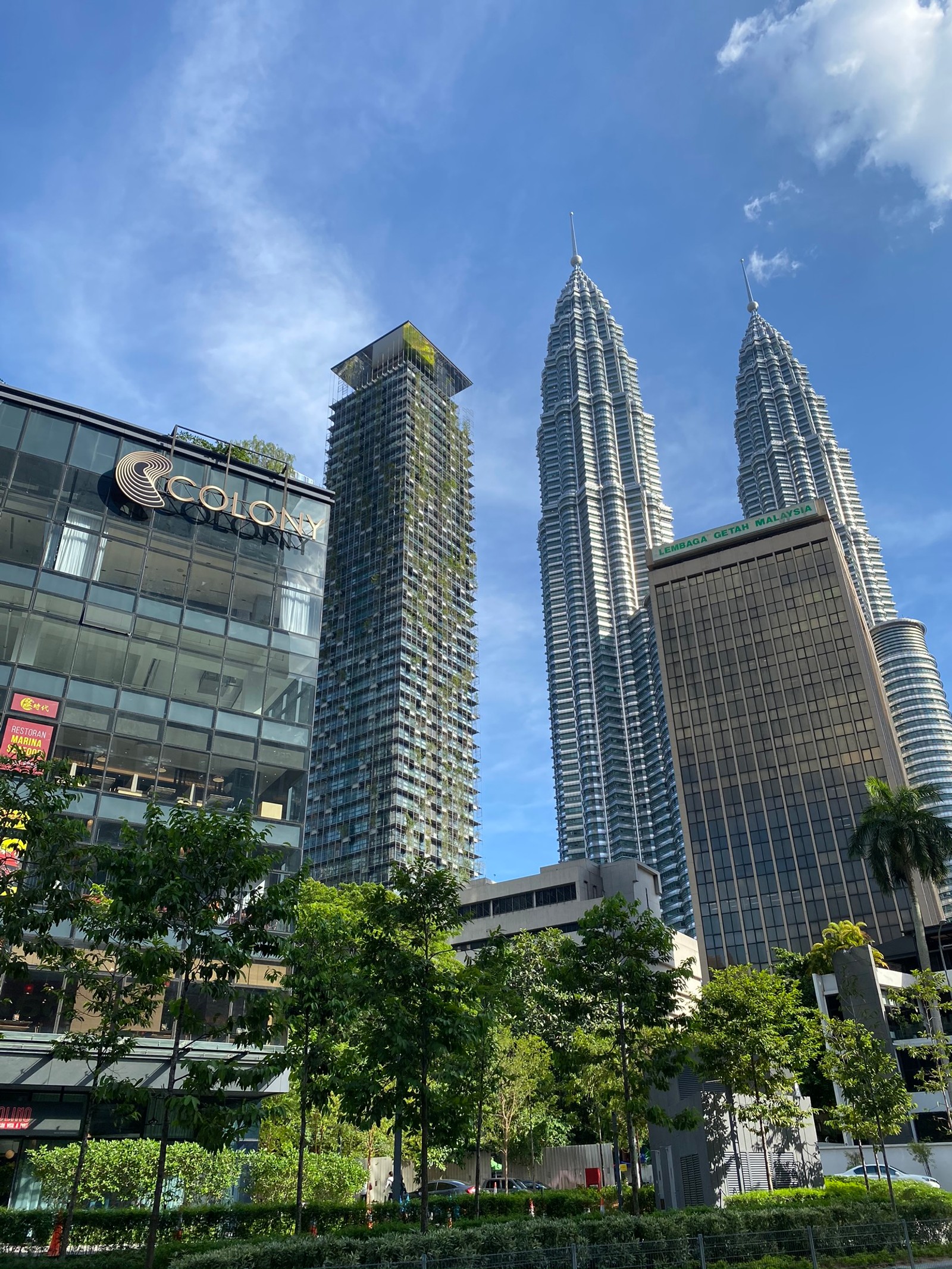 Panorama de uma cidade com prédios altos e árvores (torres petronas, kuala lumpur, dia, bloco de torre, torre)