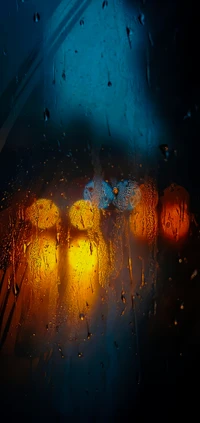 Gotas de lluvia en vidrio con luces naranjas y azules borrosas