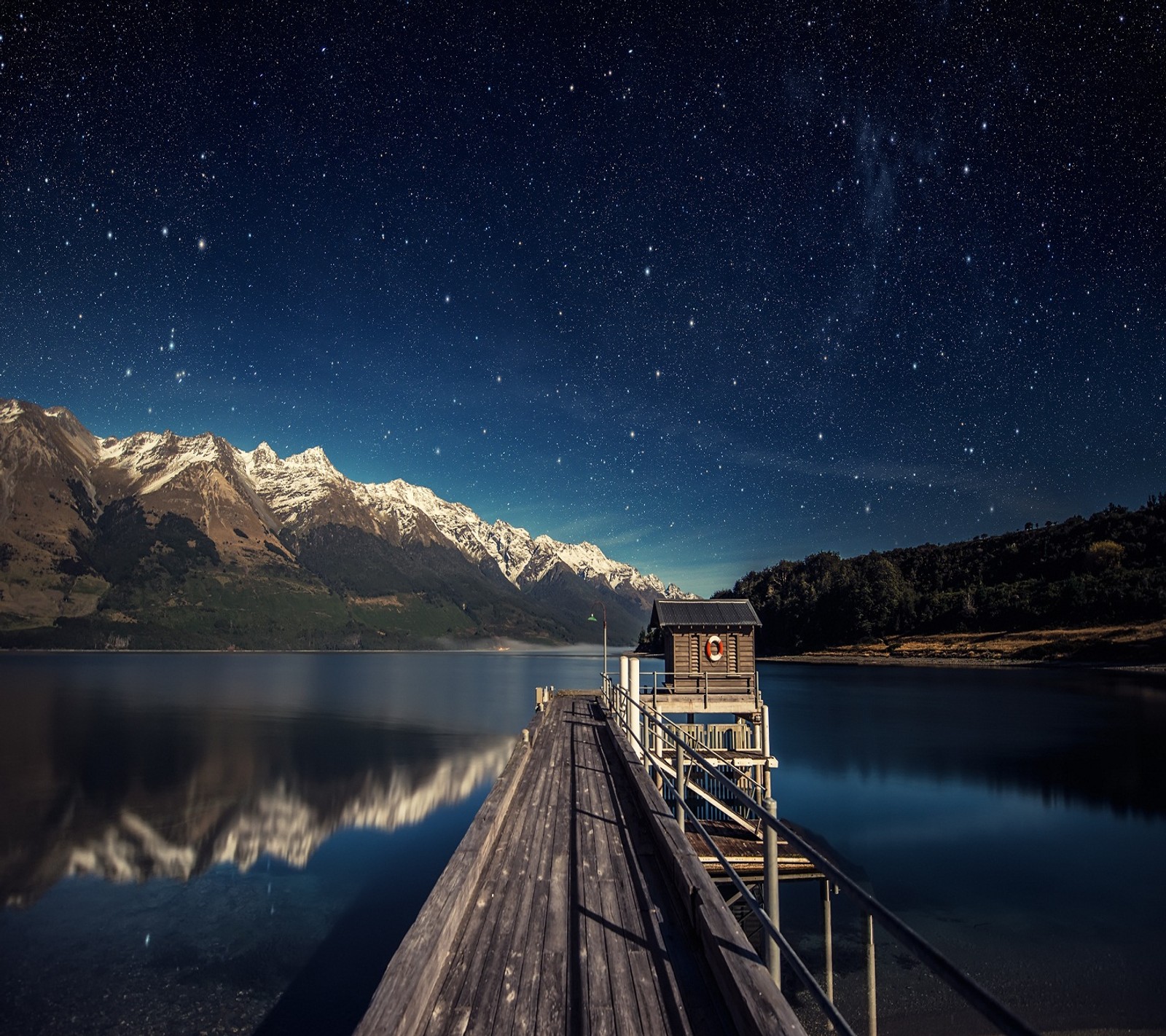 Um píer asfaltado com um barco e uma montanha ao fundo (lago, natureza)